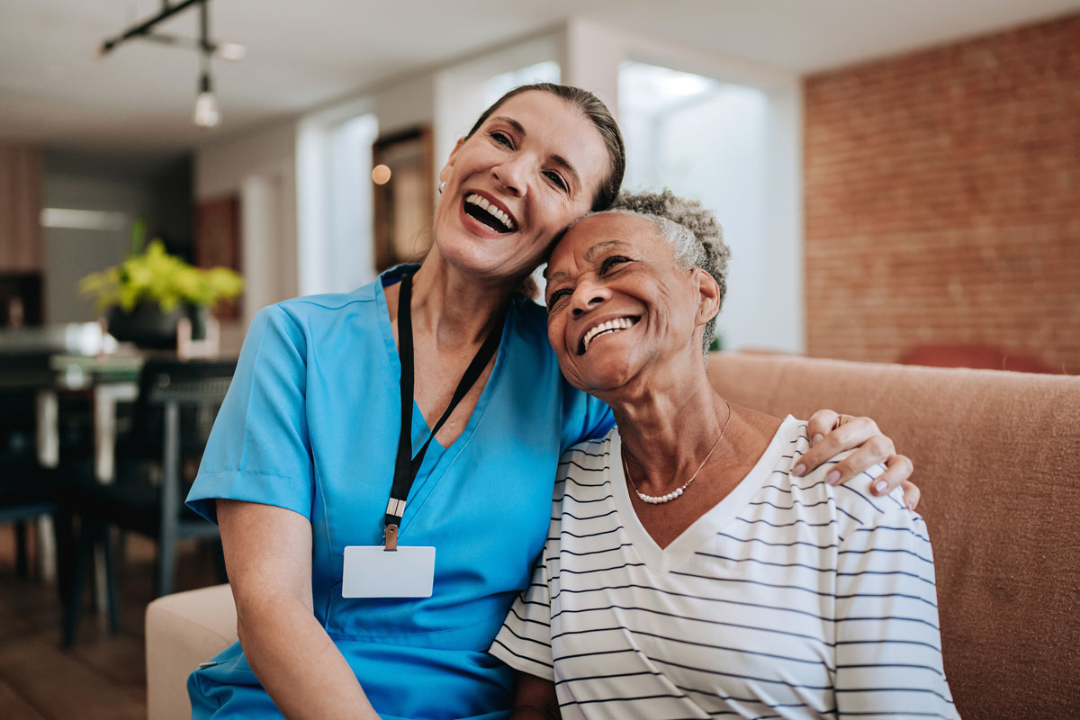 Home care healthcare professional hugging elderly patient