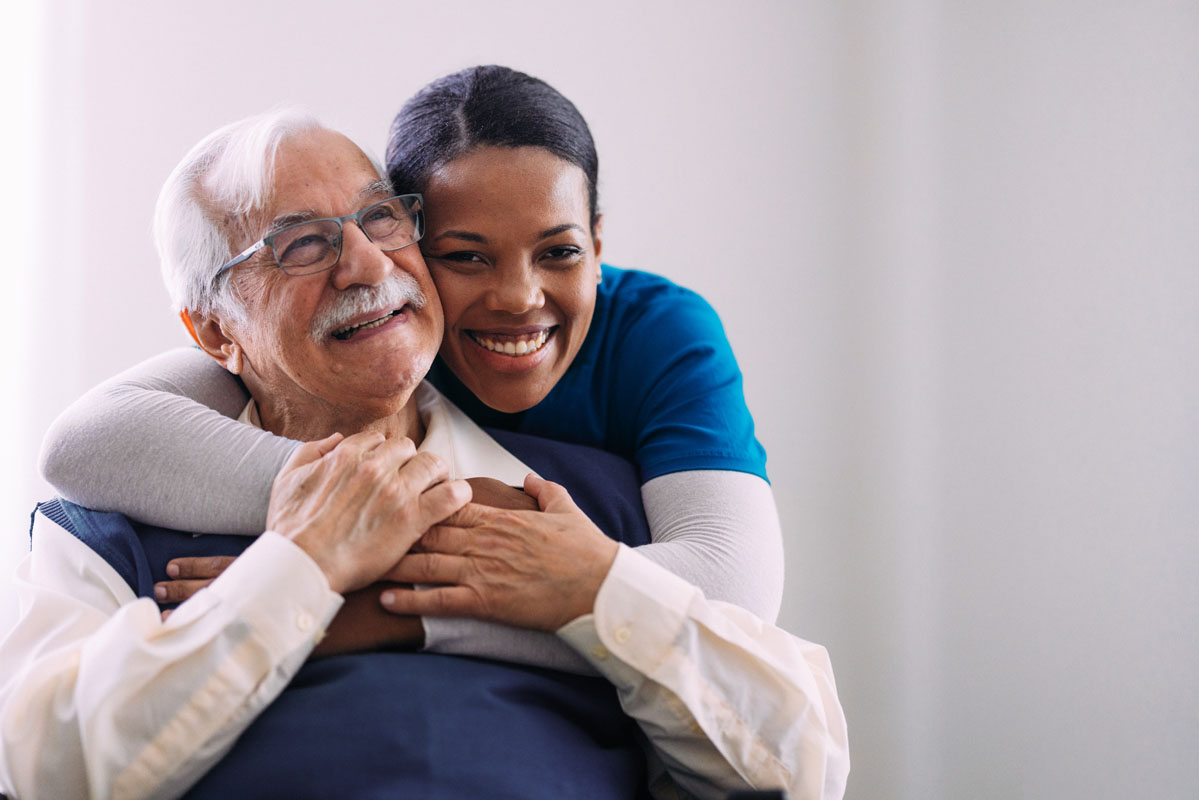 Caring Nurse Embracing Happy Elderly Man in Warm Moment